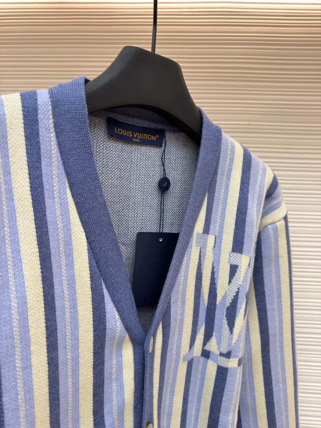 LOUIS VUITTON striped jacquard single-breasted sweater ●Original version: Purchased and developed for 15100 ●Item number: 1682314-C00 ●Fabric: wool fabric ●Technology: jacquard knitting ●Color: blue ●Version: fitted version ●Weight: about 930 grams ●Size: S-M-L-XL ●Description: This LV striped knitted cardigan is made of high-count worsted wool blended yarn. The double-ply threading process enhances the yarn's toughness. It is not easy to pill and has an outstanding drape feeling. The body of the garment adopts vertical jacquard weaving technology, with navy blue, light blue and off-white yarns interlaced with each other. The stripe width and spacing are precisely controlled by a computerized flat knitting machine, so that the color transition is natural and even. The LV letter jacquard on the left body has been debugged several times through plate making to ensure that the pattern is three-dimensional and clear. The V-neck, cuffs, and hem all use ribbing technology and are pre-shrunk to shape, making them less likely to loosen and deform after long-term wear. The buttons are made of custom-made metal, with matte sandblasting on the surface, and are hand-stitched with the seams of the body. The pockets use welting technology, and the edges are flat without jumpers. Every detail reflects the exquisite clothing craftsmanship and brand ingenuity. The overall wiring is straight and delicate, the fabric is comfortable and soft, and the color is consistent without color difference. It can be matched with the same style to create a fashionable look and control various occasions. Customized accessories, complete with three standards, same style for men and women!